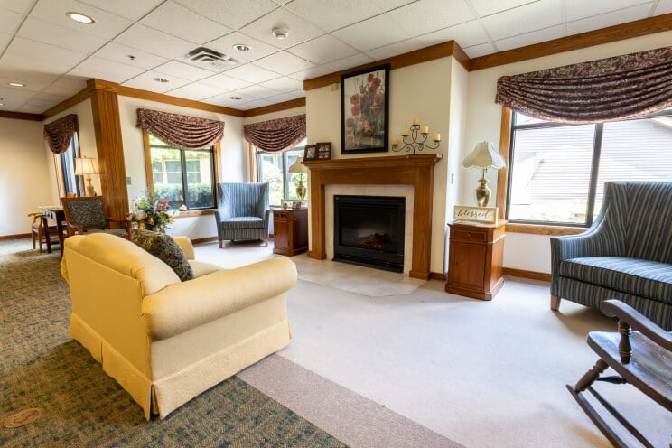 Comfortable Living Room With Fireplace and Seating at Memory Care Facility Comfortable Living Room With Fireplace and Seating at Memory Care Facility
