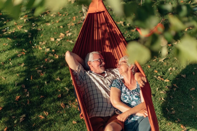 Elderly Couple Relaxing Together in Outdoor Hammock at Assisted Living Facility Elderly Couple Relaxing Together in Outdoor Hammock at Assisted Living Facility