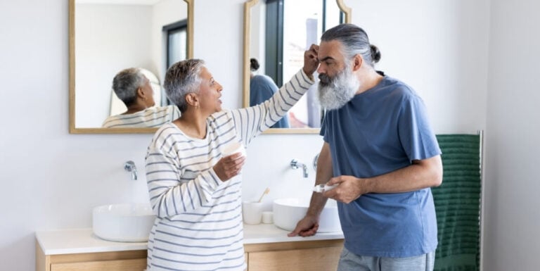 Senior Couple Supporting Each Other in Bathroom at Assisted Living Facility